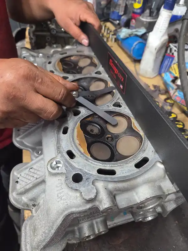 A straightedge and feeler gauge used to check a cylinder-head surface at NOFO